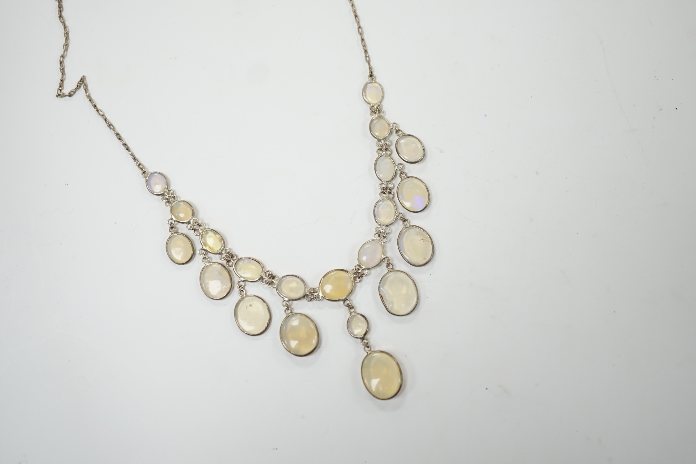 A white metal and graduated cabochon moonstone set drop necklace, 46cm. Condition - fair, one stone chipped